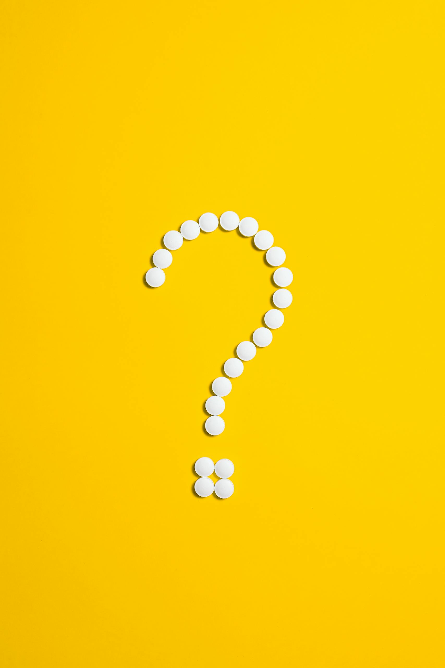 Zesty for Early Childhood Education 5 White pills arranged in a question mark shape on a bright yellow background, symbolizing medical queries.