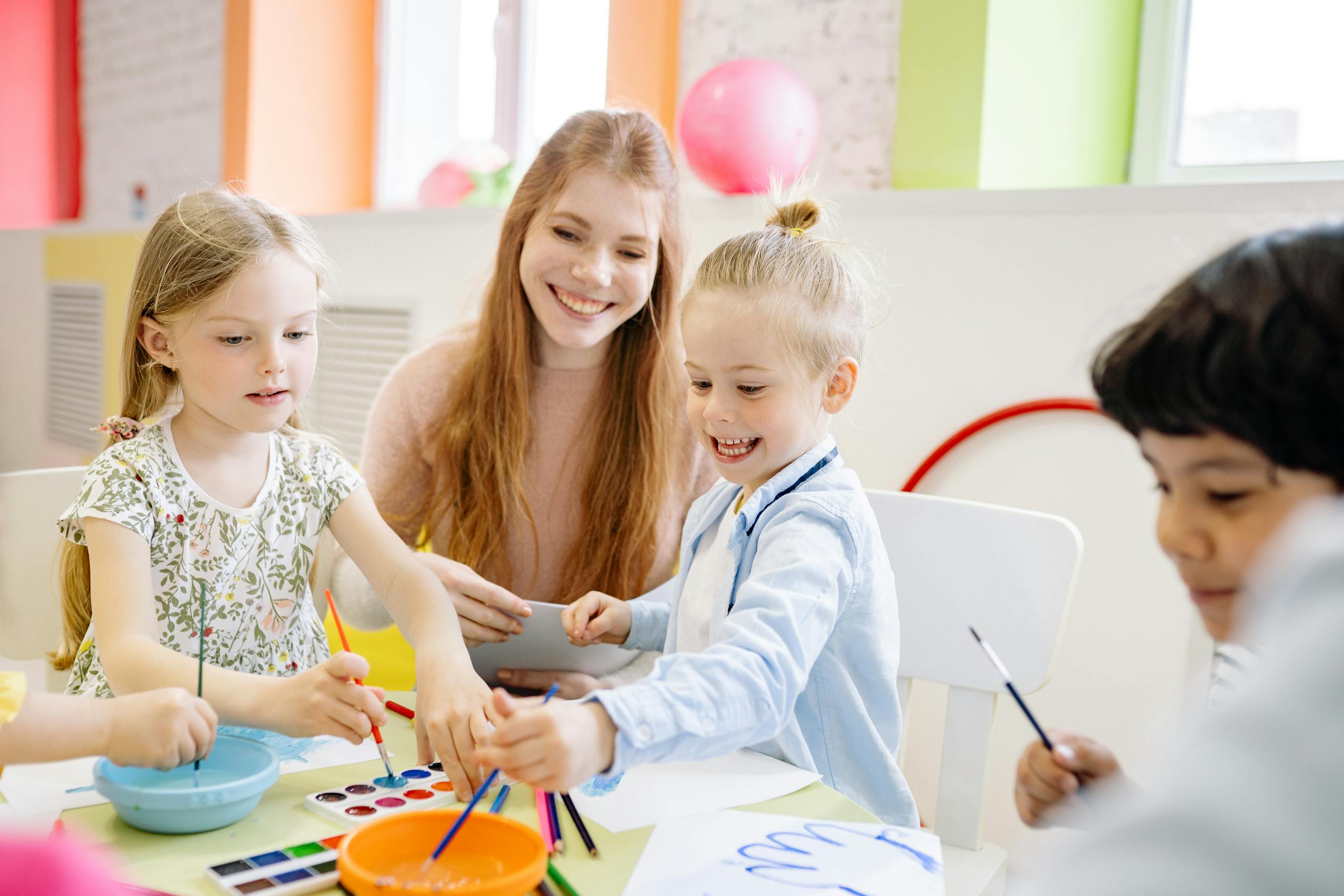 Zesty for Early Childhood Education 1 Zesty Virtual Assistants: Early Childhood Education Services | Young children enjoy painting with a teacher in a vibrant classroom setting.
